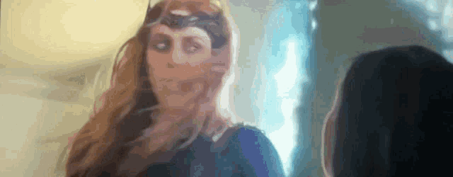 a woman in a superhero costume is standing next to another woman in a room .