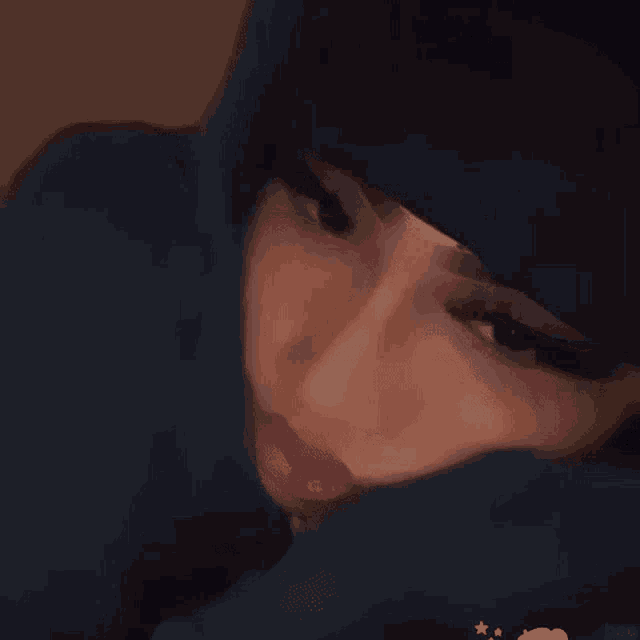 a close up of a woman 's face with a hood on her head .