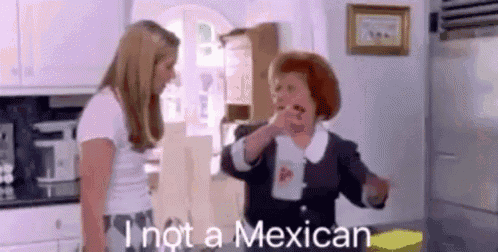 two women are standing in a kitchen talking to each other and one of them is saying `` i 'm not a mexican ''