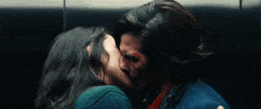 a man and a woman kissing in an elevator with blood on their faces .