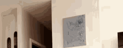 a painting is hanging on a white wall next to a door .
