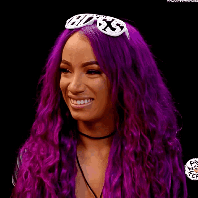 a woman with purple hair is smiling and wearing sunglasses with the word boss on them
