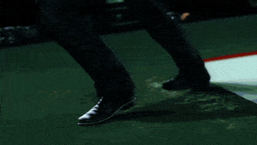 two men are kicking each other in front of a sign that says meow piwami shipbi