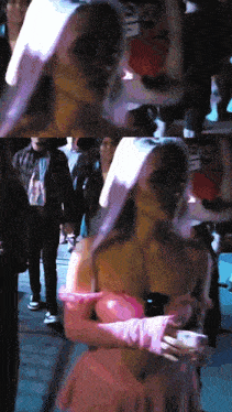 a woman in a pink dress and pink gloves stands in a crowd