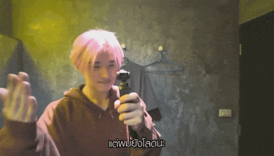 a man with pink hair is holding a camera with a caption that says ' iciw ' on it