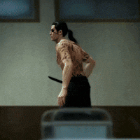 a man with a tattoo on his back is holding a knife