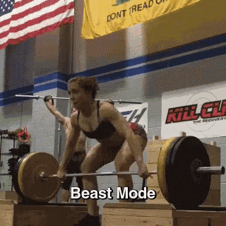 a woman is lifting a barbell in a gym with the words beast mode below her