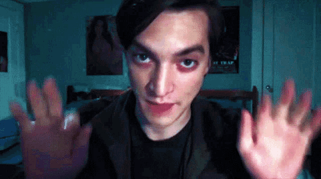 a man in a black shirt is making a funny face