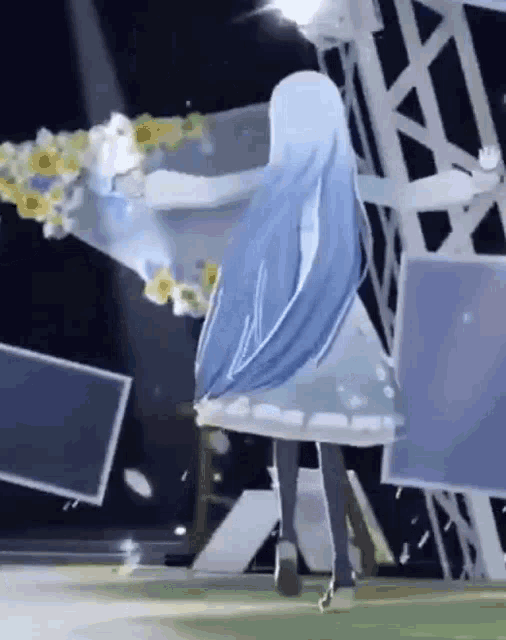 a girl in a white dress is standing on a stage with a bouquet of flowers in her hands .