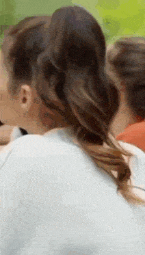 a woman with long hair is wearing a ponytail