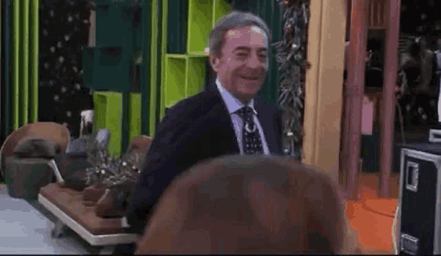 a man in a suit and tie is laughing with a woman .