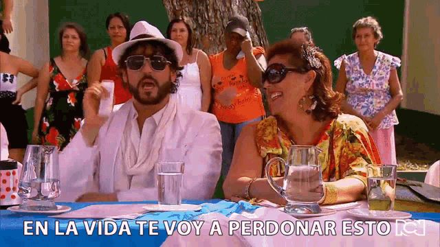 a man and a woman sit at a table with the words en la vida te voy a perdonar esto in the corner