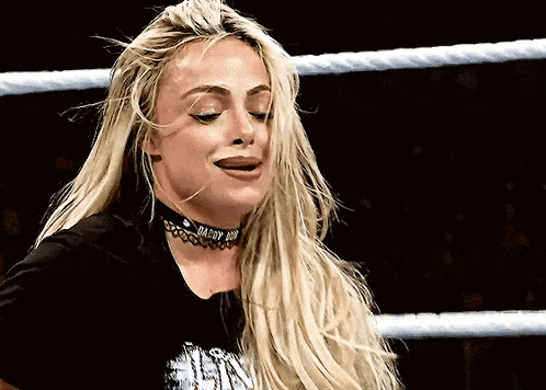 a woman with long blonde hair is wearing a choker and a black shirt .
