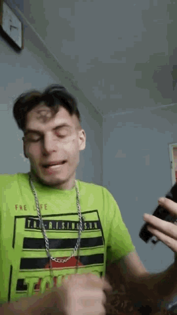 a man wearing a green shirt that says t.b. rising sun on it