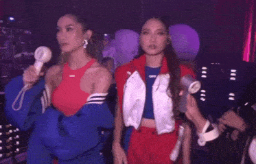 two women are standing next to each other holding hair dryers and one has the word off on her top