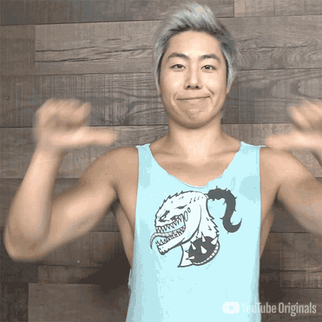 a man is wearing a blue tank top with a monster on it