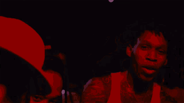 a man in a white tank top has a tattoo of a horseshoe on his arm