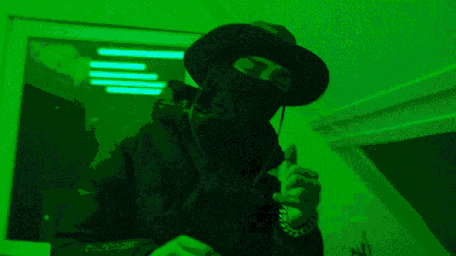 a person wearing a mask and a hat is giving a thumbs up