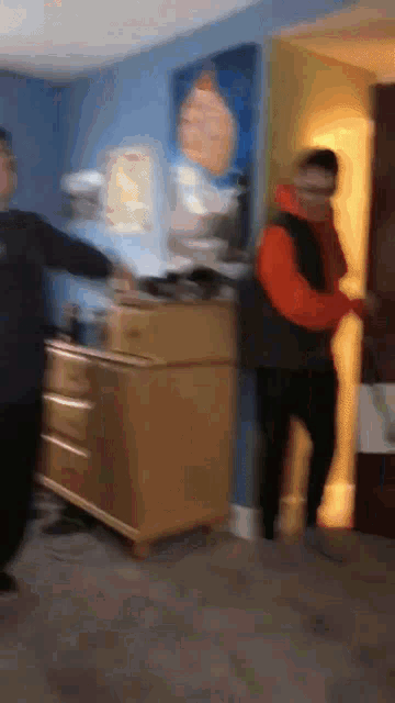 a blurry picture of a man in an orange vest standing in a room