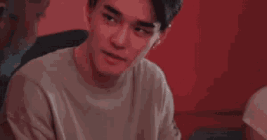 a young man is sitting in a chair with his eyes closed and looking at something .