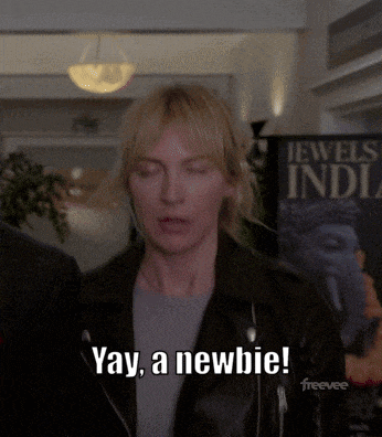 a woman says yay a newbie in front of a sign for jewels india