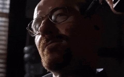 a close up of a man wearing glasses talking on a cell phone .