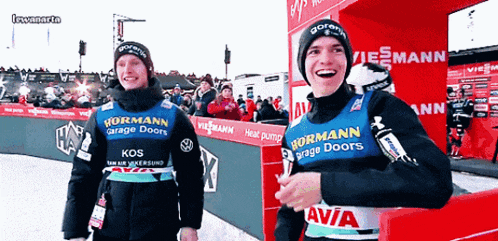two athletes wearing a vest that says hormann garage doors