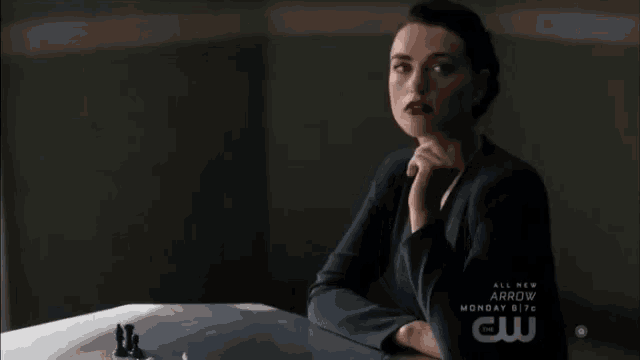 a woman sits at a table with the words all new arrow monday at the bottom of the screen