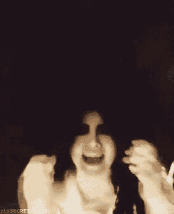 a black and white photo of a person covering their face with their hands .