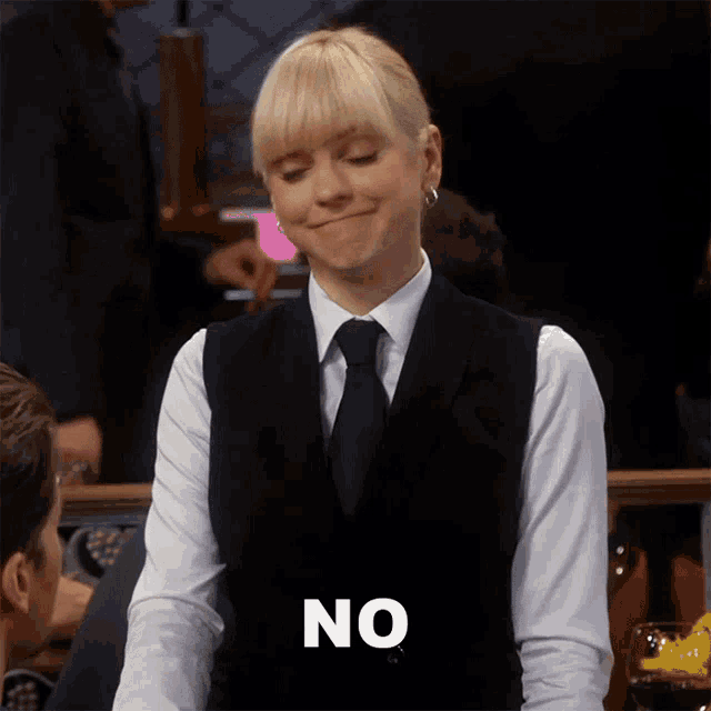 a woman wearing a black vest and tie says no