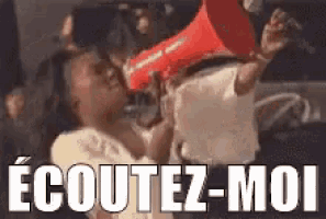 a woman is holding a red megaphone in front of a crowd and says `` ecoutez-moi '' .