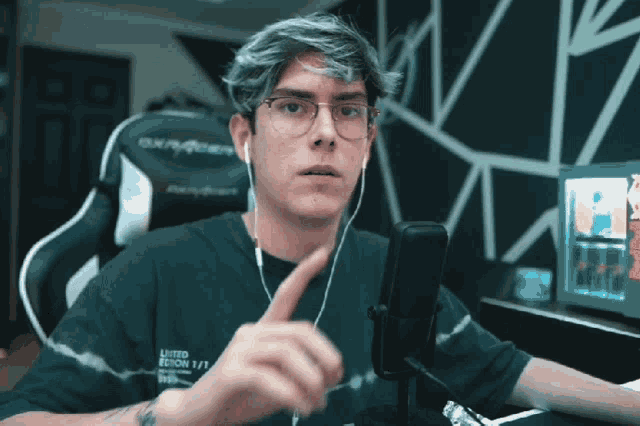 a man wearing headphones and a shirt that says limited edition is sitting in front of a microphone