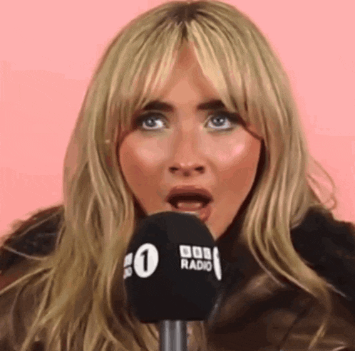a woman is speaking into a microphone that says bob radio