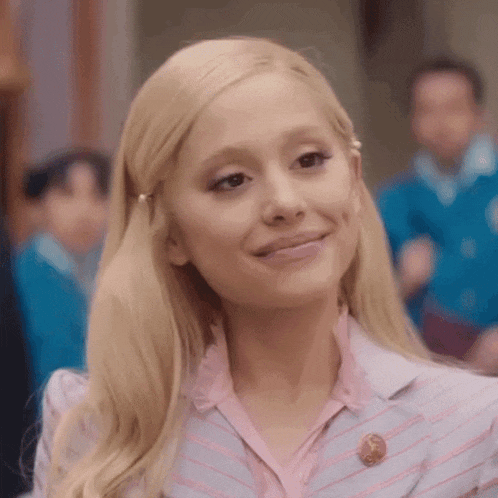 ariana grande is wearing a pink and blue striped suit and a pink shirt .