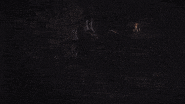 a woman in a witch hat is reading a book in a dark room .