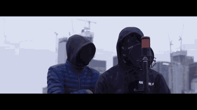 a man in a hooded jacket stands next to another man in a hooded jacket with the word rus on it