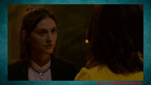 a woman in a yellow jacket talks to another woman