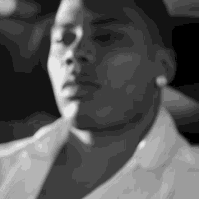 a black and white photo of a man 's face with his eyes closed