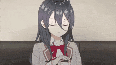 a girl with long black hair is sitting on a couch