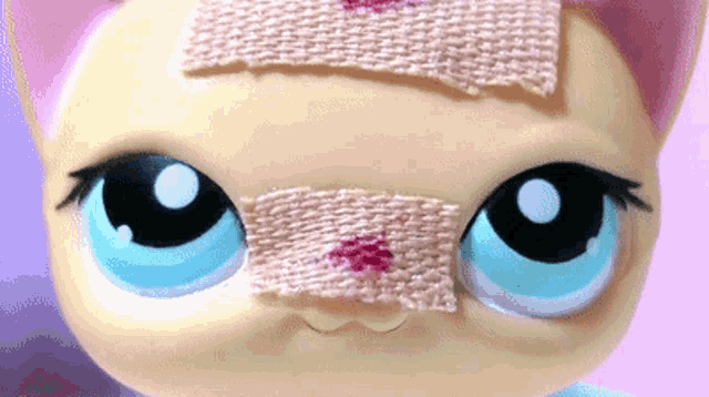 a close up of a toy with a bandage on its face