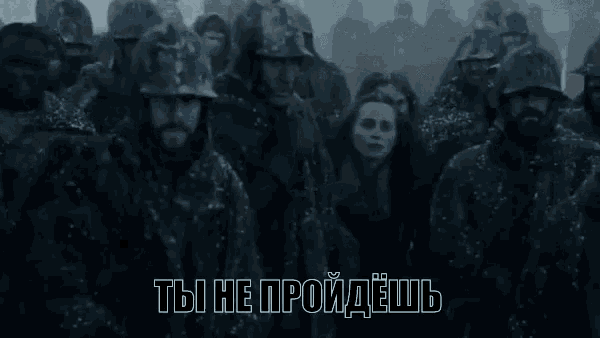 a group of people are standing next to each other in a dark room with russian writing on the bottom .