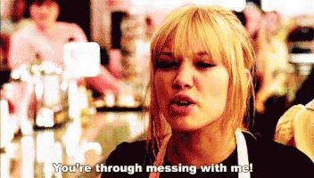 a woman in an apron is saying you 're through messing with me