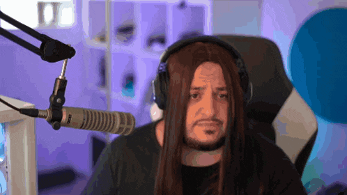a man with long hair wearing headphones and a microphone