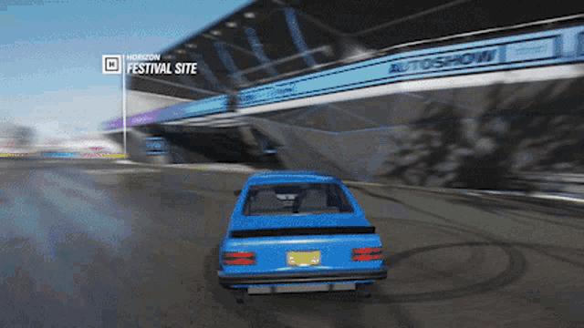a blue car is driving in front of a horizon festival site sign