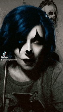 a woman with blue hair and a clown make up has tiktok written on the bottom