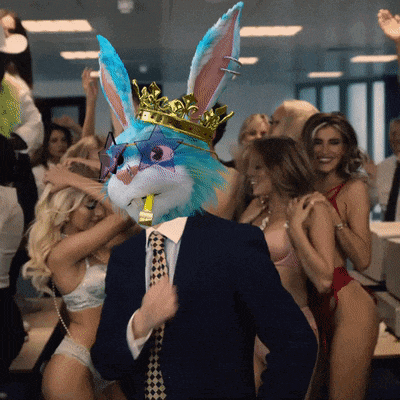 a man with a bunny mask on his head is surrounded by women