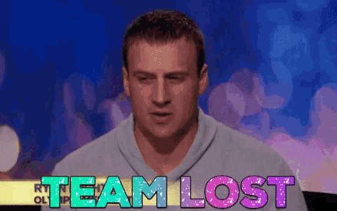 a man in a grey sweater stands in front of a sign that says team lost