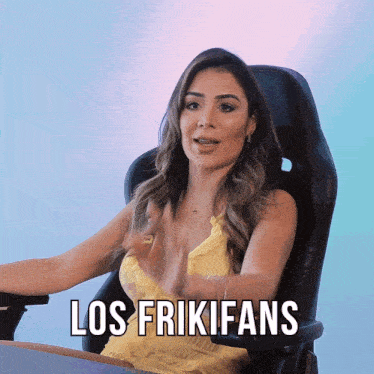 a woman in a yellow dress is sitting in a chair with los frikifans written on the bottom