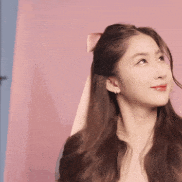 a woman with a ribbon in her hair looks up