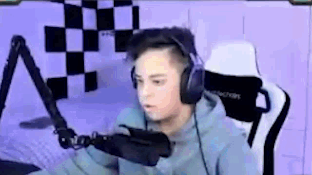 a young boy wearing headphones and a microphone is sitting in front of a microphone .